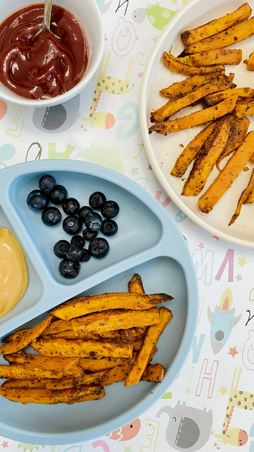 Healthy snack plate with baked sweet potato fries, creamy spicy mayo, and fresh blueberries.